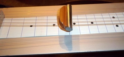 You need a Steel to play it. This one was a 5/8&quot; stainless steel bolt &amp; a scrap of Deodar Cedar. The fret board is heavy paper &amp; ink. The strings were reclaimed from string changes.